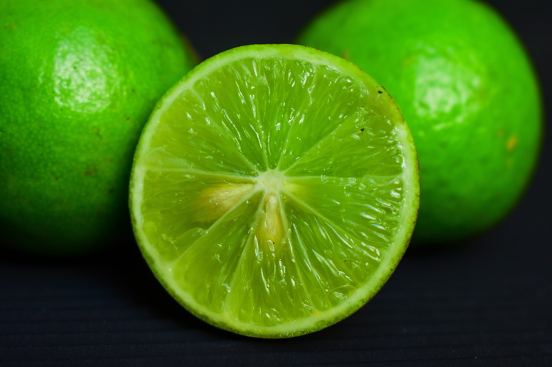 colored background, citrus fruit, fruit, slice, juicy, black background, lime, citrus, indoors, no people, studio shot, group of objects, lemon, healthy