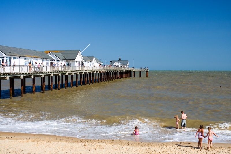 clear sky, horizon over water, group of people, water, blue, day, beauty in nature, sunny, pier, architecture, outdoors, built structure, motion, suffolk