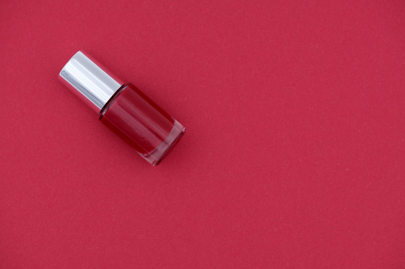 studio shot, copy space, silver colored, still life, indoors, color, manicure, nail varnish, red background, single object, coupon, close-up, fingernails