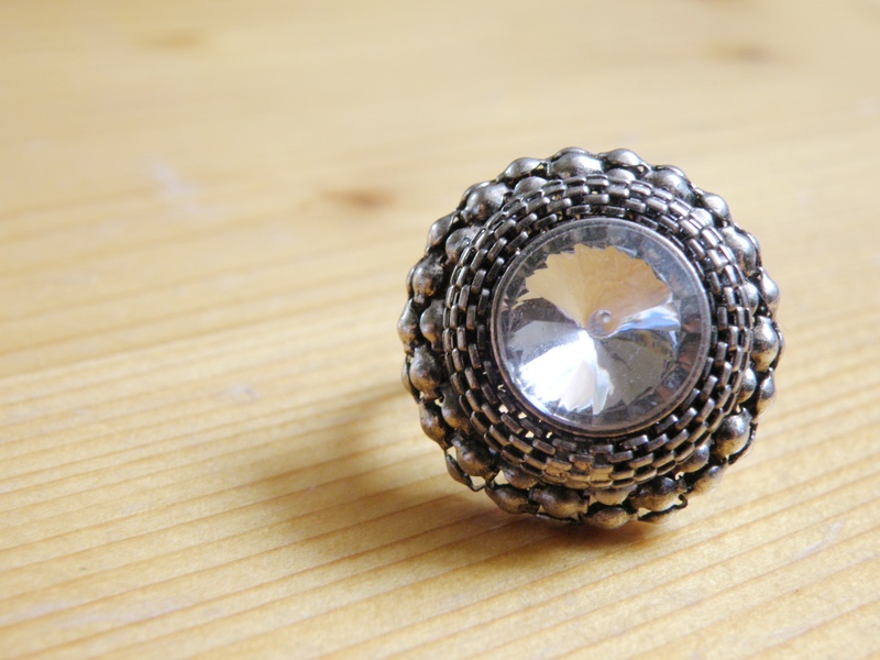 table, jewelry, high angle view, gemstone, silver colored, wood - material, single object, ring, antique, ornament, focus on foreground, encrusted, fashion