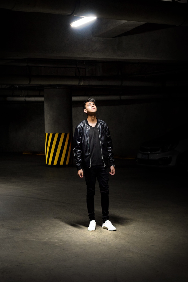 face, staring, young men, fashion, looking at camera, highlight, one person, coat, full length, men, model, illuminated, carpark, leather, real people