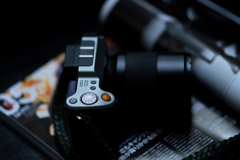 dial telephone, photographic equipment, nostalgia, technology, close-up, strap, lens cap, camera lens, finger, video gaming, black color, adapter, single object
