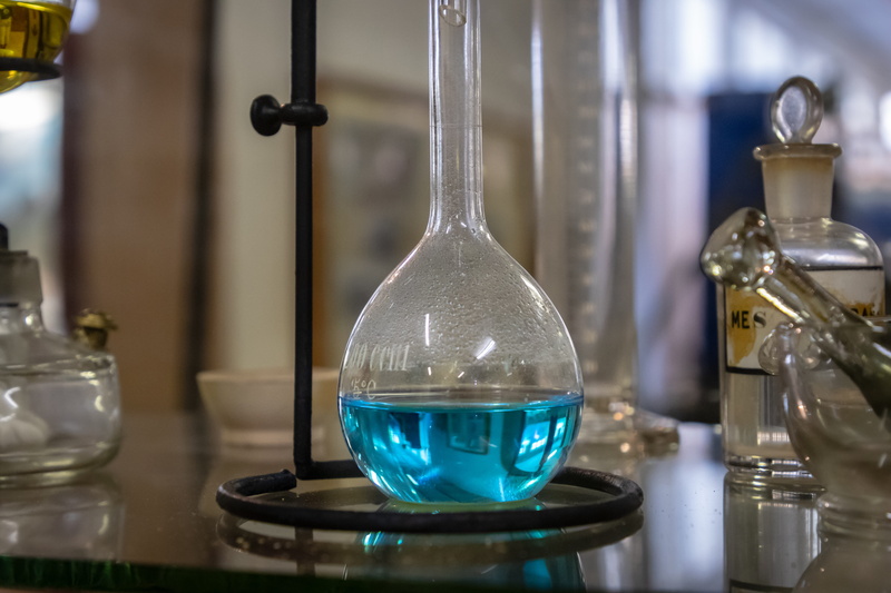 flask, close-up, lighting equipment, cocktail, transparent, home decor, bottle, reflection, shelf, sphere, crystal, indoors, focus on foreground, wine glass