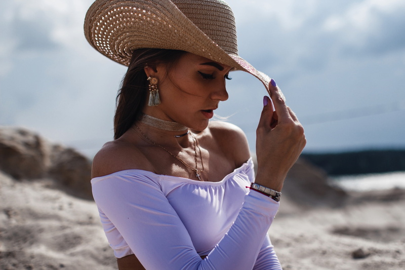 holding, necklace, land, 2K, one person, outdoors, bare shoulders, fashion, eyeliner, beach, young adult, portrait, leisure activity, focus on foreground