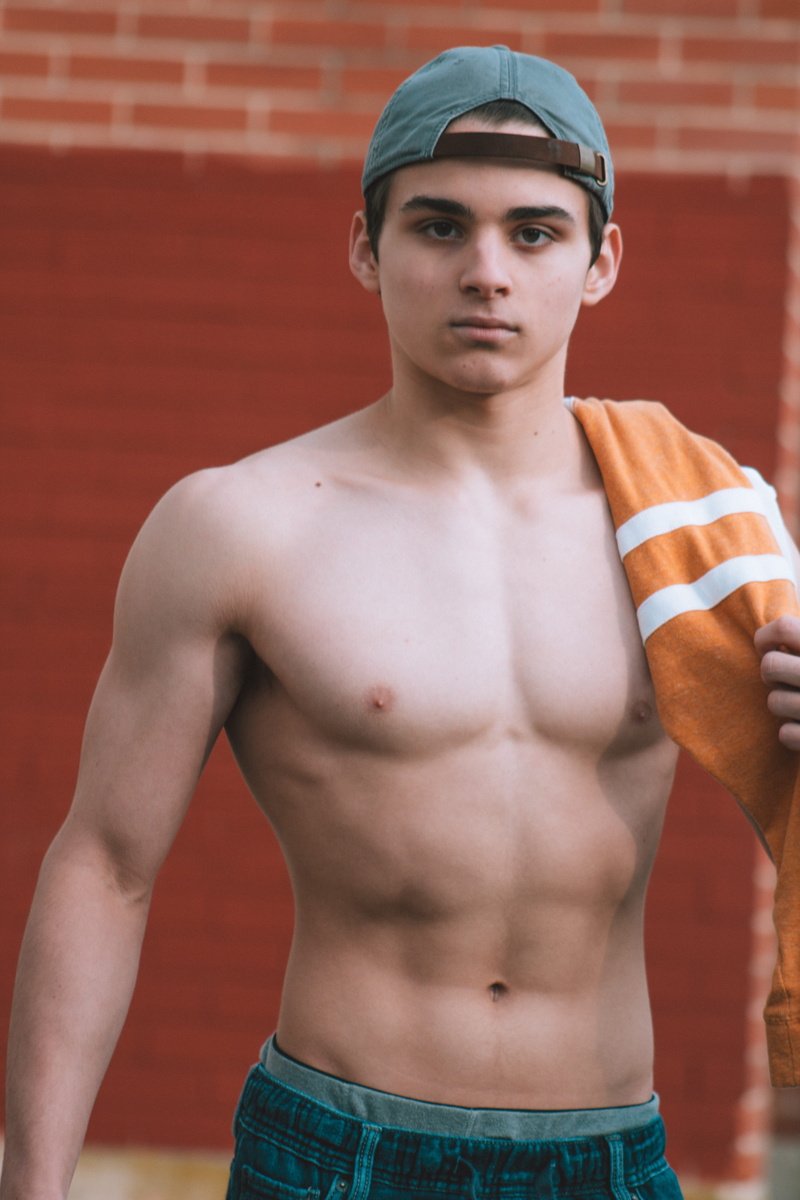 bottoms, shirtless, 5K, real people, wearing, front view, one person, attitude, young adult, wall, sport, holding, standing, orange, muscular build, portrait