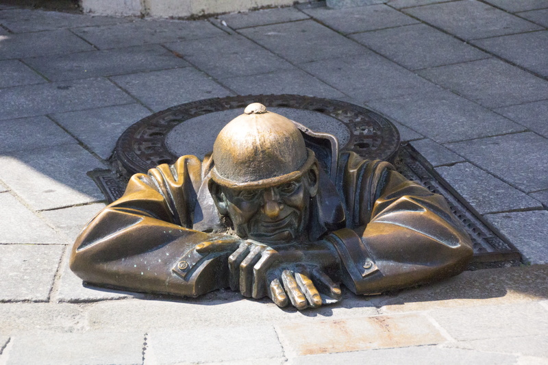 sunlight, shadow, sidewalk, statue, footpath, nature, manhole cover, high angle view, craft, creativity, bronze, street, male likeness, human representation