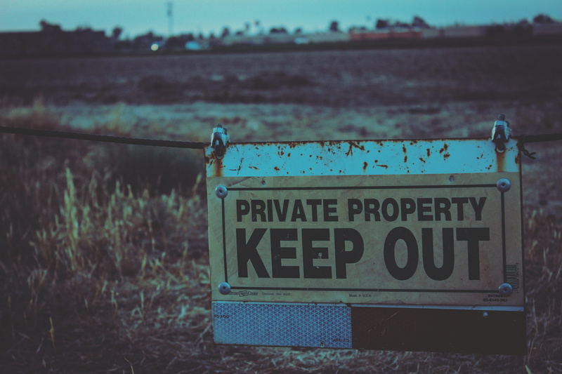 signboard, grass, outdoors, landscape, guidance, warning, road, communication, signage, sign, information sign, non-western script, hanging, text, information