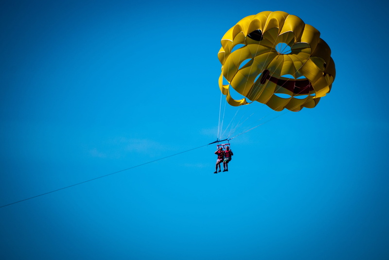 outdoors, parasailing, travel, sea, rope, nature, the coast, freedom, tourism, mid-air, low angle view, day, leisure activity, extreme sports, flying, summer