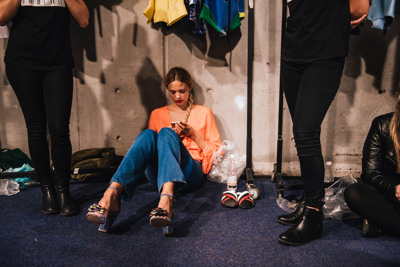 calm, fashion, model, leisure activity, mobile, city, cell, front view, runway, phone, girl, real people, relax, day, sunlight, sitting, women, woman, fashion week