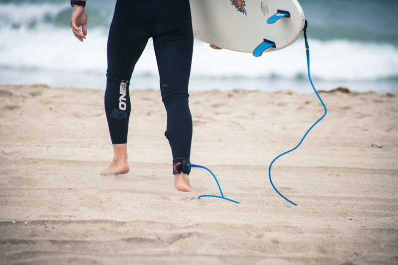 standing, real people, human limb, body part, low section, surf, focus on foreground, men, human foot, land, lifestyles, day, adult, surfboard, one person