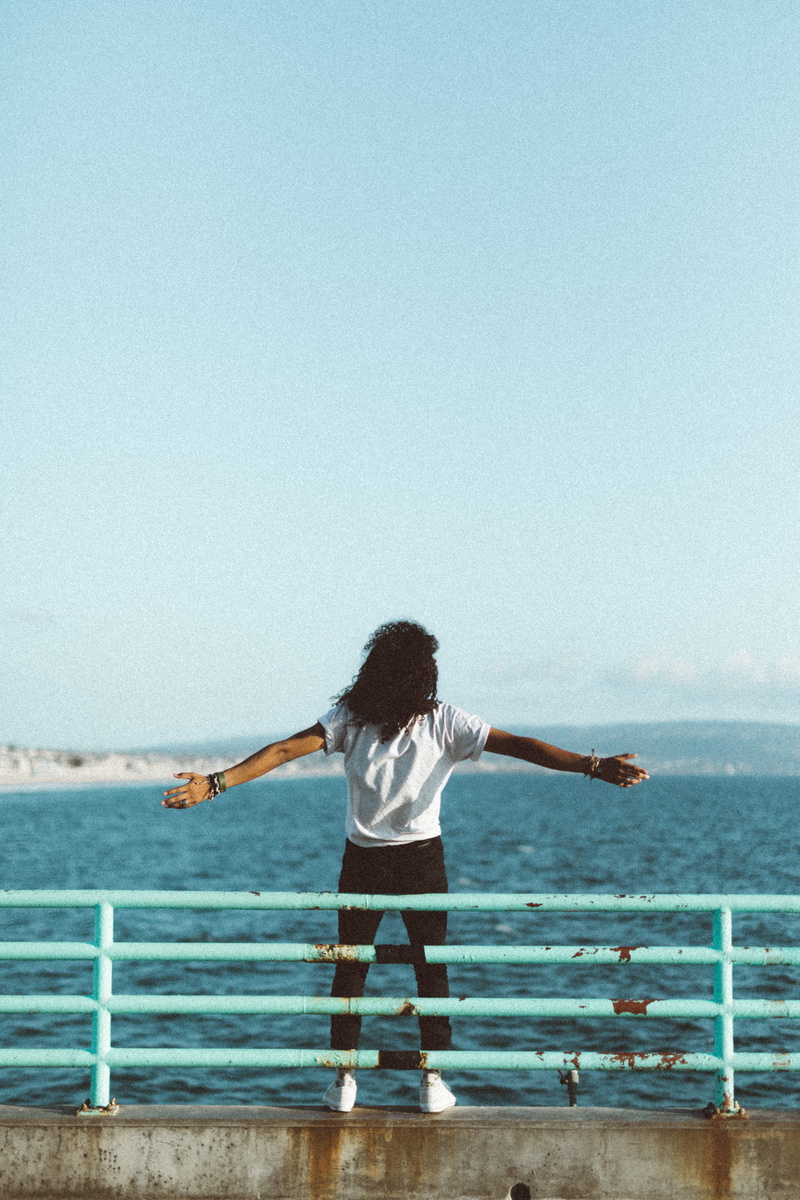 rear view, metal, casual clothing, sea, daytime, portrait, standing, one person, on the edge, day, sky, real people, wanderlust, on ledge, ocean, rails