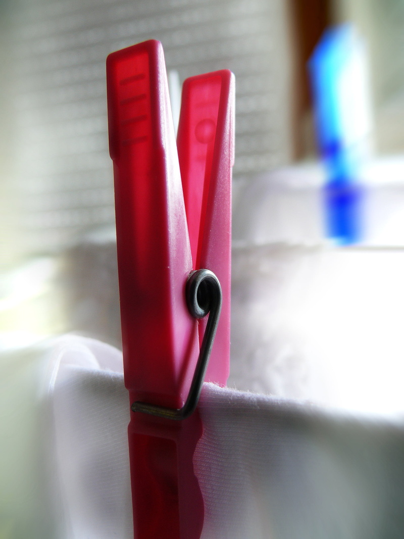 home interior, laundry, indoors, plastic, clip, architecture, close-up, metal, red, man made, clothes peg, still life, table, focus on foreground, no people