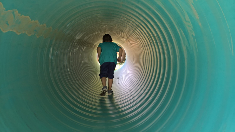 tunnel, lifestyles, circle, person, way, rippled, digital composite, full length, teenager, shorts, outdoor, fun, shape, end, childhood, indoors, pipe