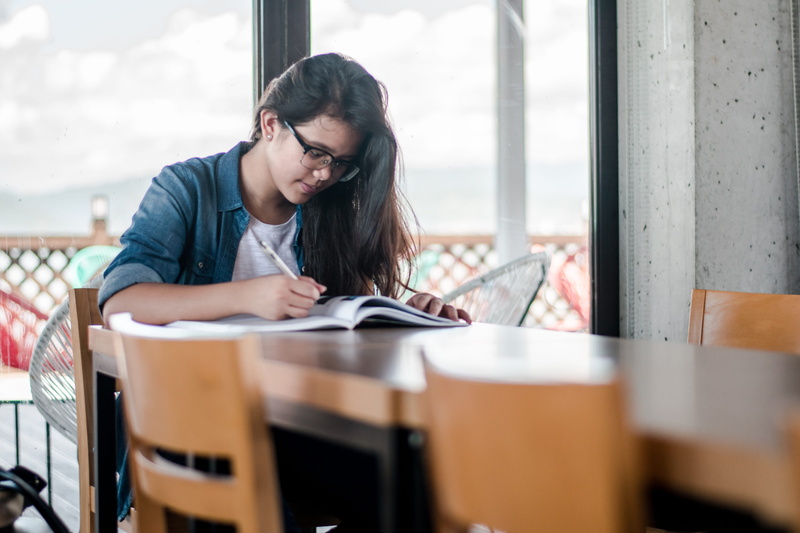 reading, paper, sitting, woman, girl, activity, desk, young adult, female, learning, writing, people, hairstyle, book, publication, young women, school