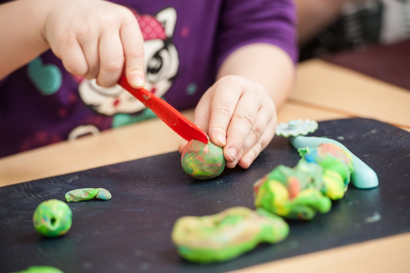 indoors, healthy eating, one person, play, plastic, clay, childhood, domestic room, vegetable, toy, midsection, people, creativity, human hand, knife, preparing food