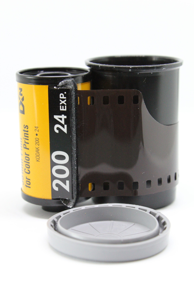 negative, strip, table, indoors, vintage, old, black color, yellow, shape, filmstrip, still life, communication, celluloid, 35mm, text, isolated, film canister