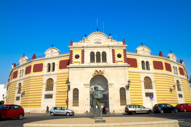 plaza toros, travel, building, history, car, building exterior, arch, nature, clear sky, Almeria, government, Av, architecture, flag, blue, land vehicle