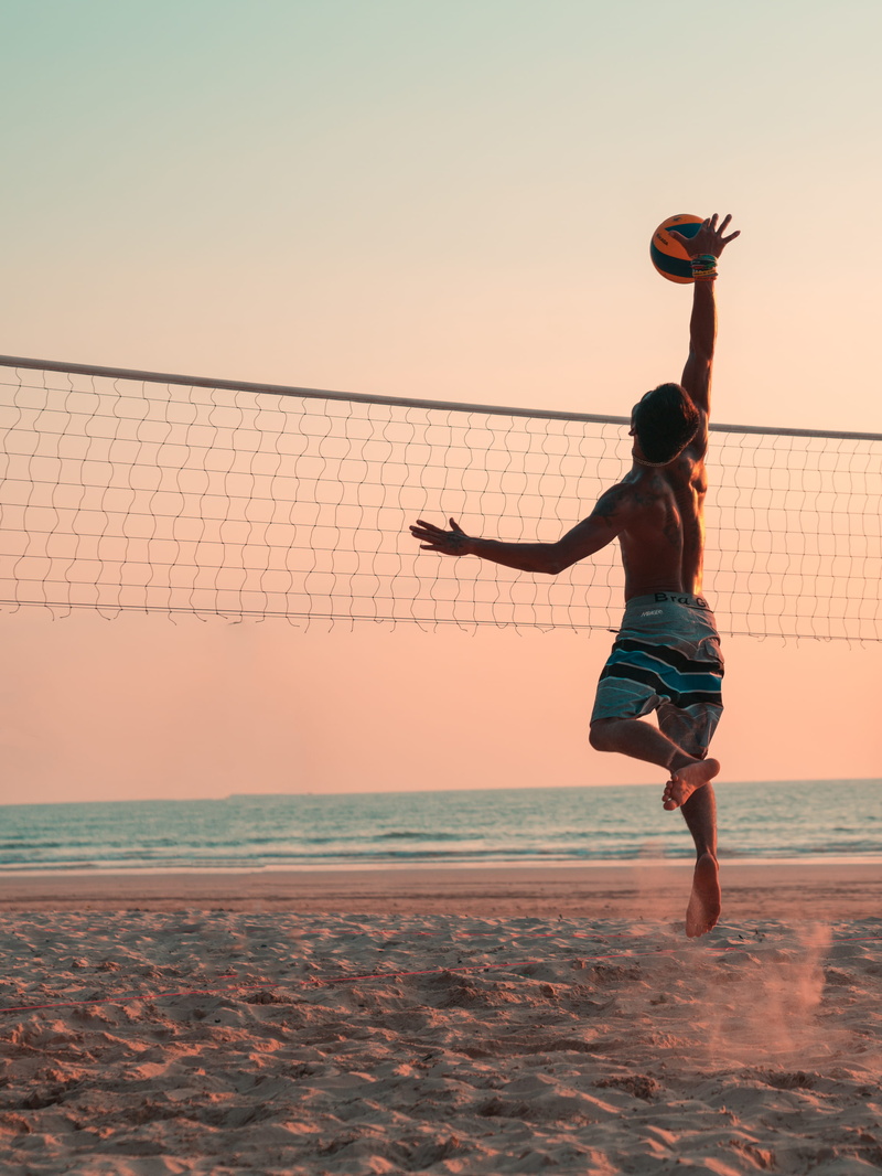 sport, ball, mid-air, motion, human arm, beauty in nature, arms raised, net, playing, nature, exercise, sea, jumping, orange color, land, beach, person