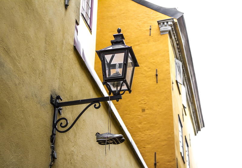 old city, outdoors, street light, sketchers, europe, building exterior, wall, window, shoes on a wire, street, low angle view, sneakers, stockholm, no people