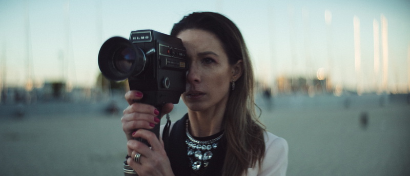 front view, standing, focus on foreground, selective, filming, adult, hairstyle, camera, holding, lifestyles, 4K, casual clothing, sunrise, anamorphic
