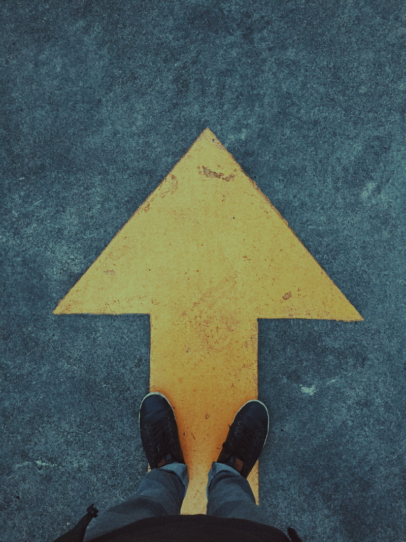 person, sign, human leg, street, style, rooftop, urban, point, personal perspective, outdoors, symbol, body part, denim, real people, human limb, high angle view