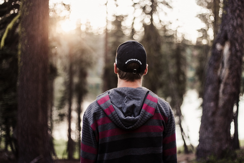 young man, trees, one person, front, trucker hat, selective, leisure activity, photo, behind, focus on foreground, cap, plant, woodland, sweater, focus