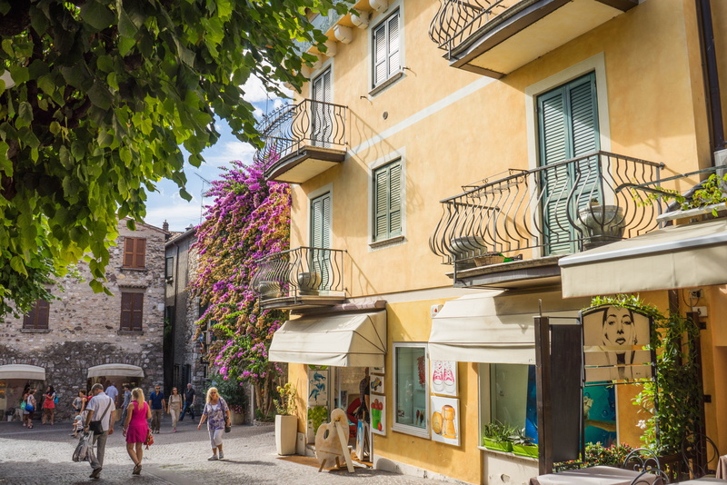 incidental people, day, nature, architecture, medieval, building exterior, lake garda, sirmione, plant, lombardy, city, street, men, group of people, tree