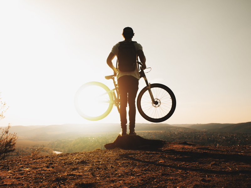 land vehicle, outdoors, landscape, Sun Rays, sport, bike, sunlight, bicycle, sky, standing, rear view, leisure activity, cyclist, one person, silhouette