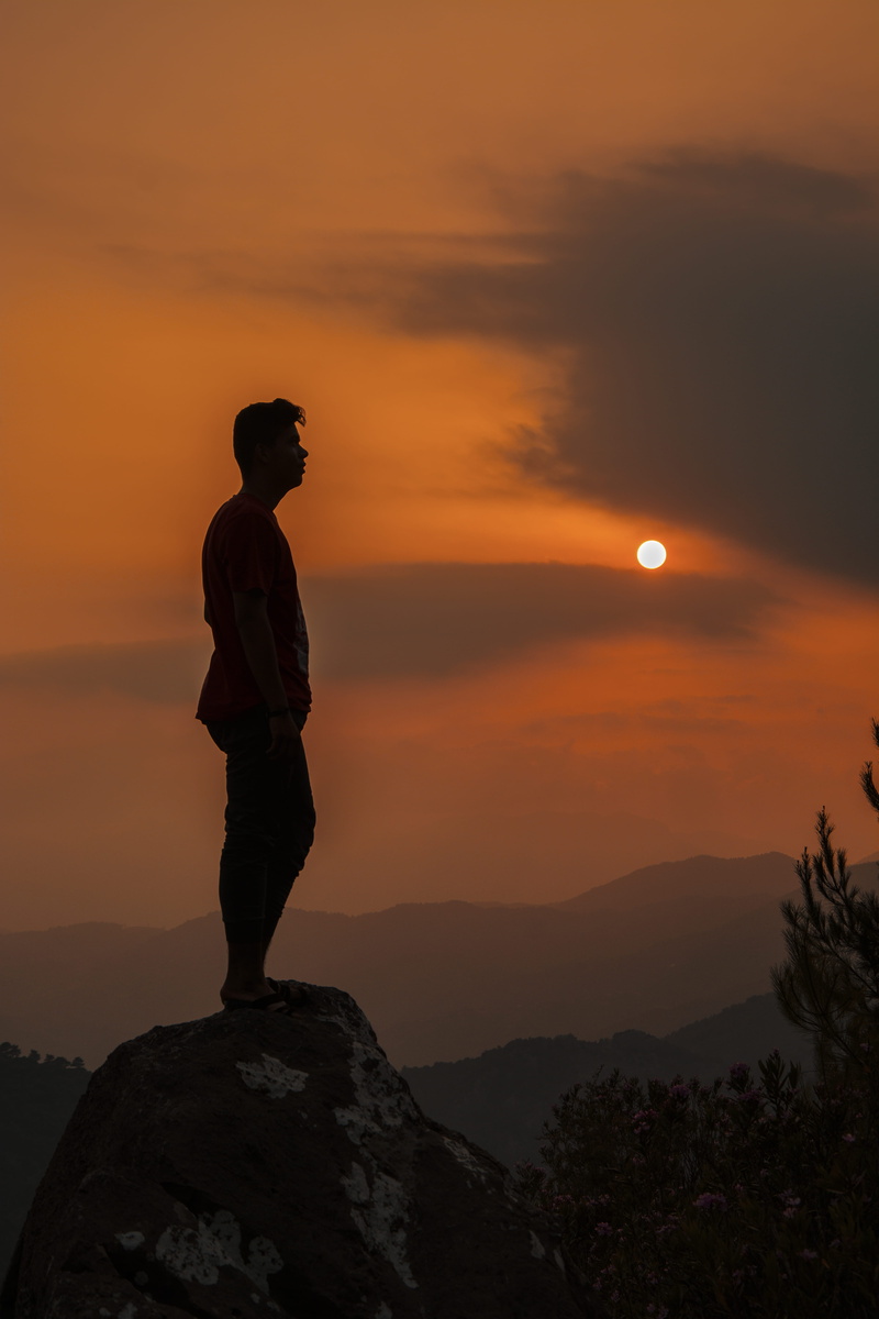 male, rock, sun, orange color, outdoors, guy, one person, standing, cliff, beauty in nature, tranquility, tranquil scene, leisure activity, mountain, silhouette