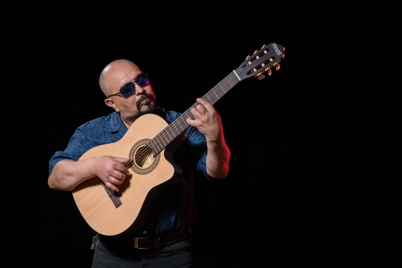 guitarist, strumming, musical instrument, entertainment, plucking an instrument, adult, human limb, black background, indoors, arms raised, stringed instrument