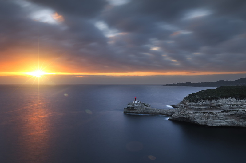 tranquil scene, water, land, outdoors, photography nature clouds sunset sun lighthouse rocks mountains sea far view optical flares, sky, cloud - sky, nature