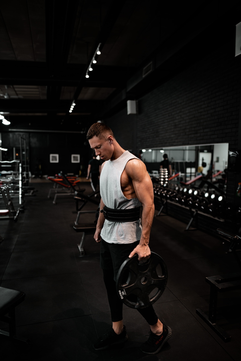 clothing, suit, holding, indoors, working out, exercise, gym, full length, plate, one person, tank, human, men, kneeling, lifestyles, leisure activity