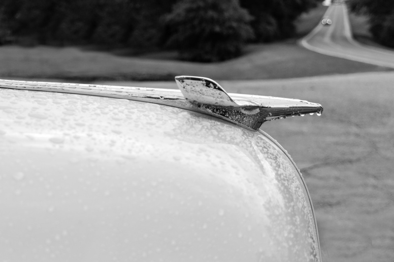 car, rain, chevrolet, outdoors, black and white, nature, music, transportation, book, paper, vehicle, single object, automobile, antique, focus on foreground