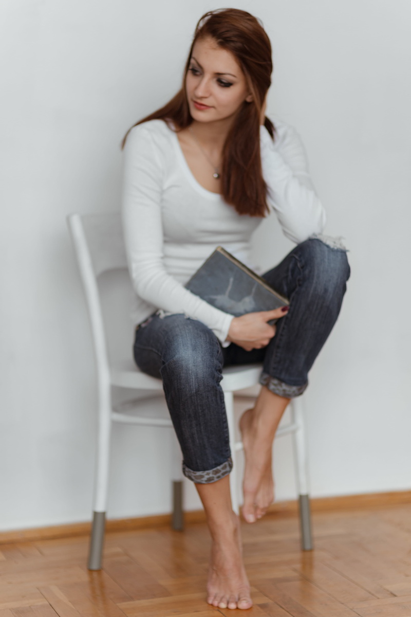 full length, indoors, young adult, long hair, flooring, front view, lifestyles, caucasian, young women, adult, brown hair, book, woman, home interior, reading
