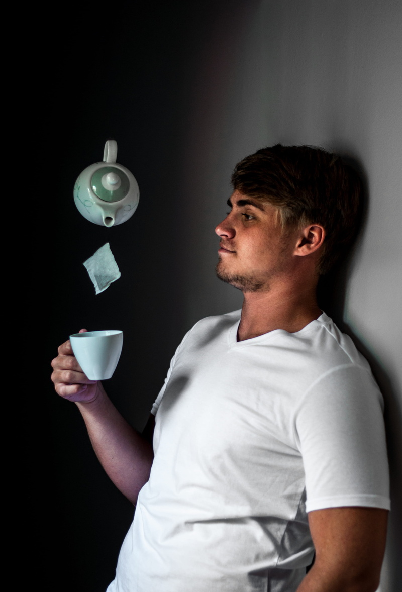 one person, facial expression, magic, lifestyles, tea cup, young adult, drink, young men, floating, white, actor, wear, man, trick, standing, refreshment