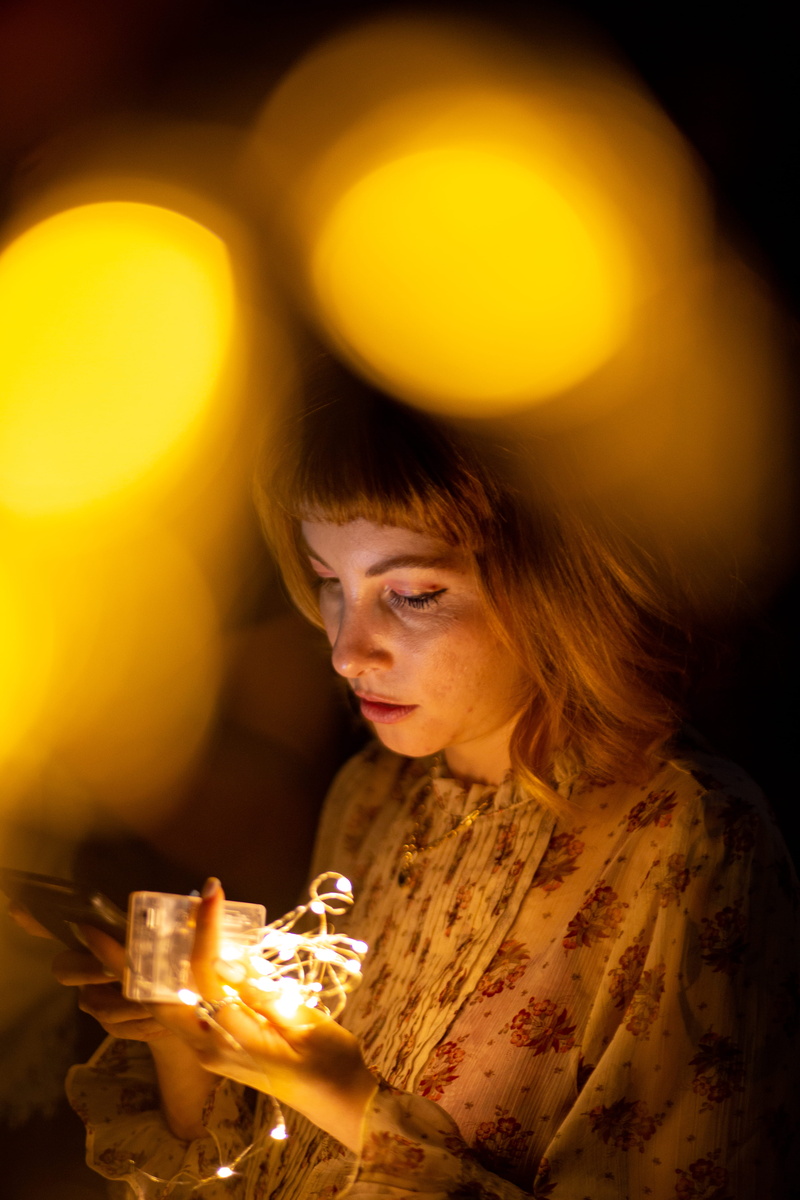 eyes, portrait, fashion, 5K, close-up, holding, casual, string lights, evening, night, woman, wear, hairstyle, illuminated, focus, attractive, model, looking