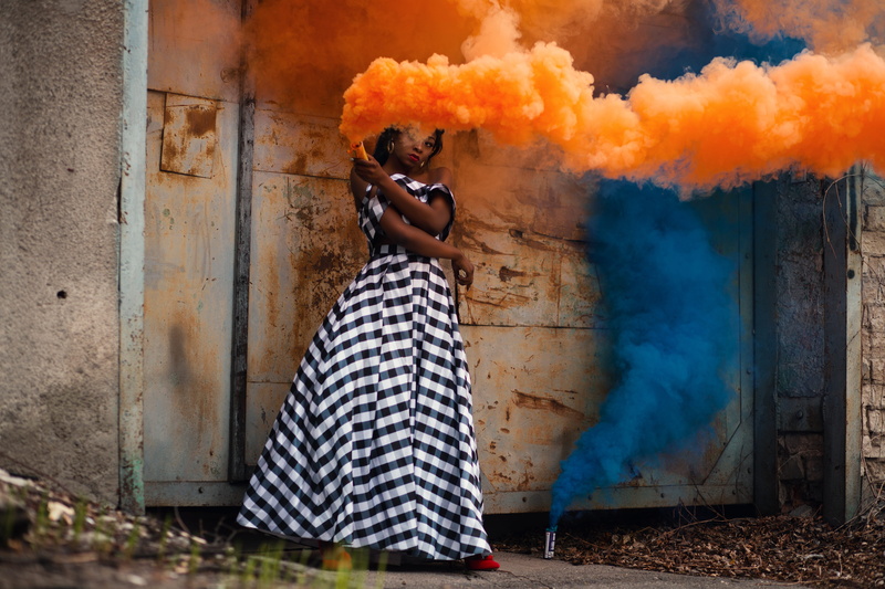 women, smoke - physical structure, pose, fire, day, burning, real people, one person, model, smoke, looking, fire - natural phenomenon, architecture, holding