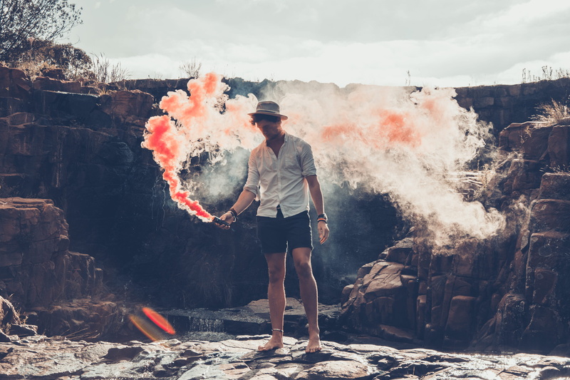 leisure activity, young men, real people, nature, lifestyles, outdoors, man, casual clothing, men, bomb, smoke bomb, full length, front view, burning, one person