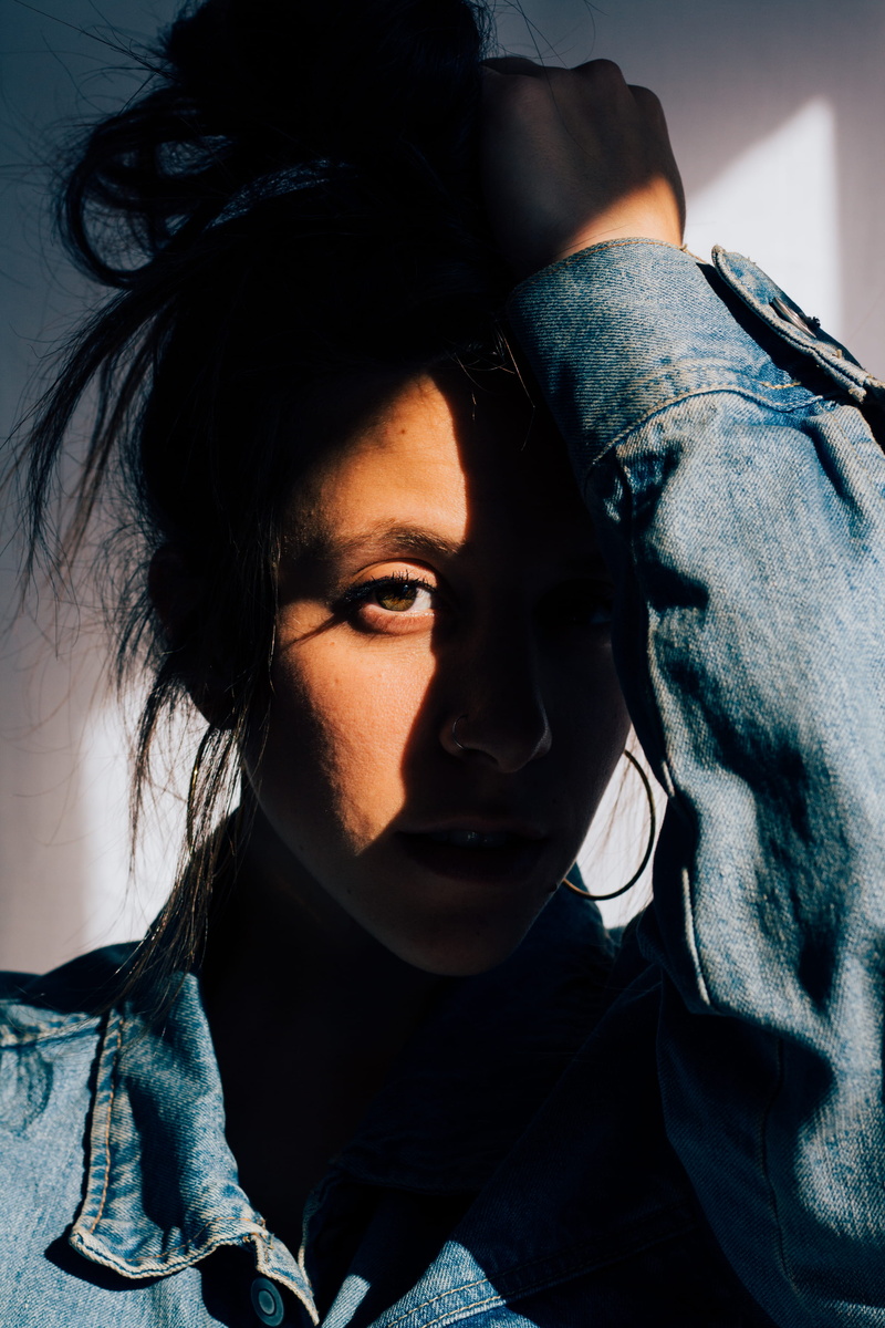 contemplation, jeans, close-up, looking at camera, hand on head, casual clothing, home interior, person, photography, sunlight, lifestyles, human, adult