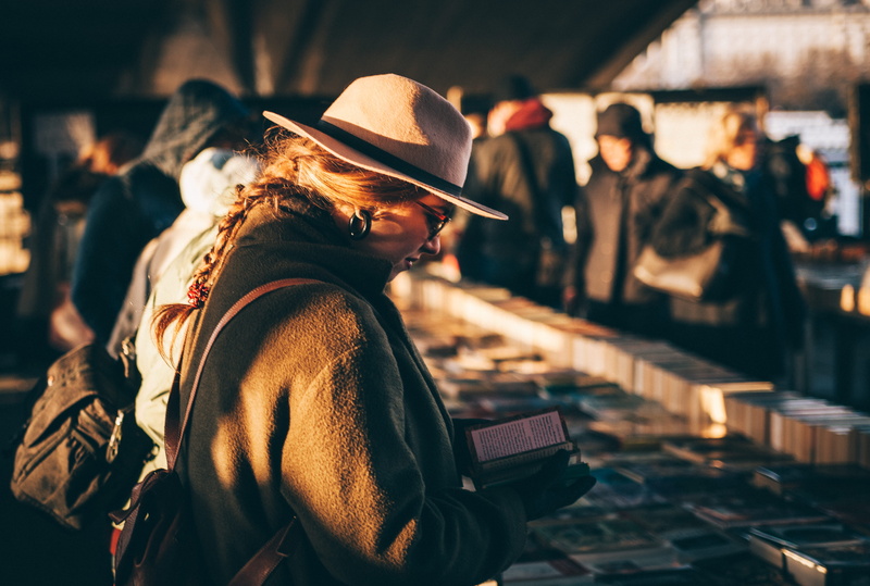 backpack, lifestyles, 5K, united kingdom, book, hat, city, real people, focus on foreground, market, lady, woman, architecture, clothing, looking, waist up