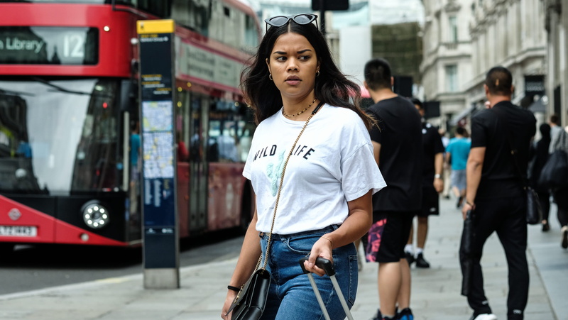 looking at camera, mode of transportation, trolley, one person, sunglasses, luggage, front view, casual clothing, day, urban, station, united kingdom, standing