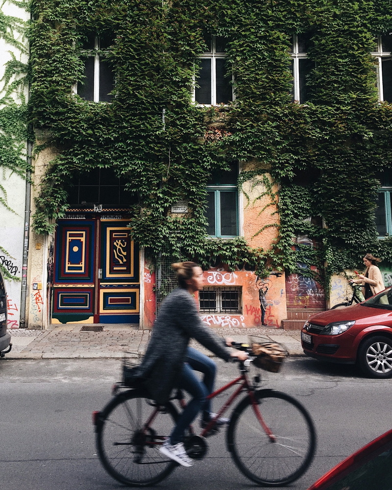 traffic, daylight, riding, cyclist, house, bike, tree, road, built structure, car, beside, city, concrete, real people, full length, wheel, transportation