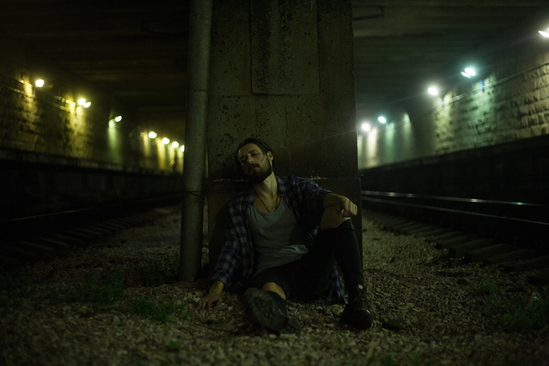 t, mode of transportation, neck, contemplation, person, man, rail transportation, shirt, clothing, architecture, illuminated, front view, tired, transportation