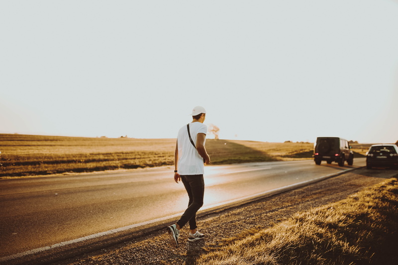 casual clothing, sky, hat, field, travel, 5K, clear sky, one person, guidance, highway, outdoors, adult, road, transportation, wear, standing, mode of transportation
