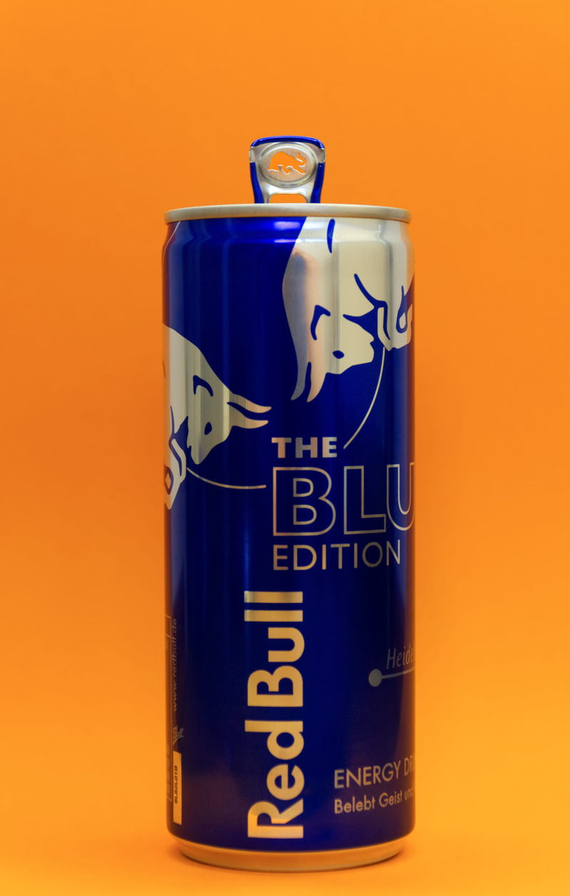 still life, blue, softdrink, orange color, container, communication, energy, text, bull, red background, colored background, refreshment, energydrink, no people