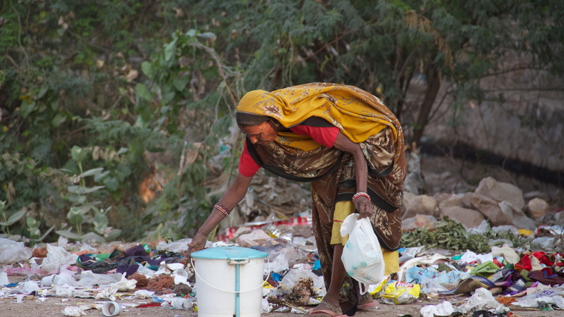 one person, white, clothing, blue, garbage, container, pollution, outdoors, holding, india, recycling, woman, bending, real people, dirty, adult, leisure activity