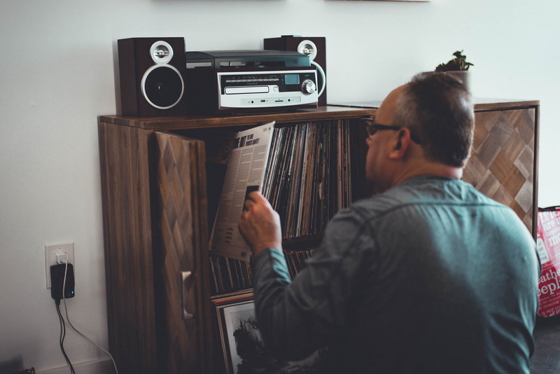 speaker, brown, book, casual clothing, record player, occupation, man, record, interior, wooden, music, listening, shirt, room, front, indoor, modern art