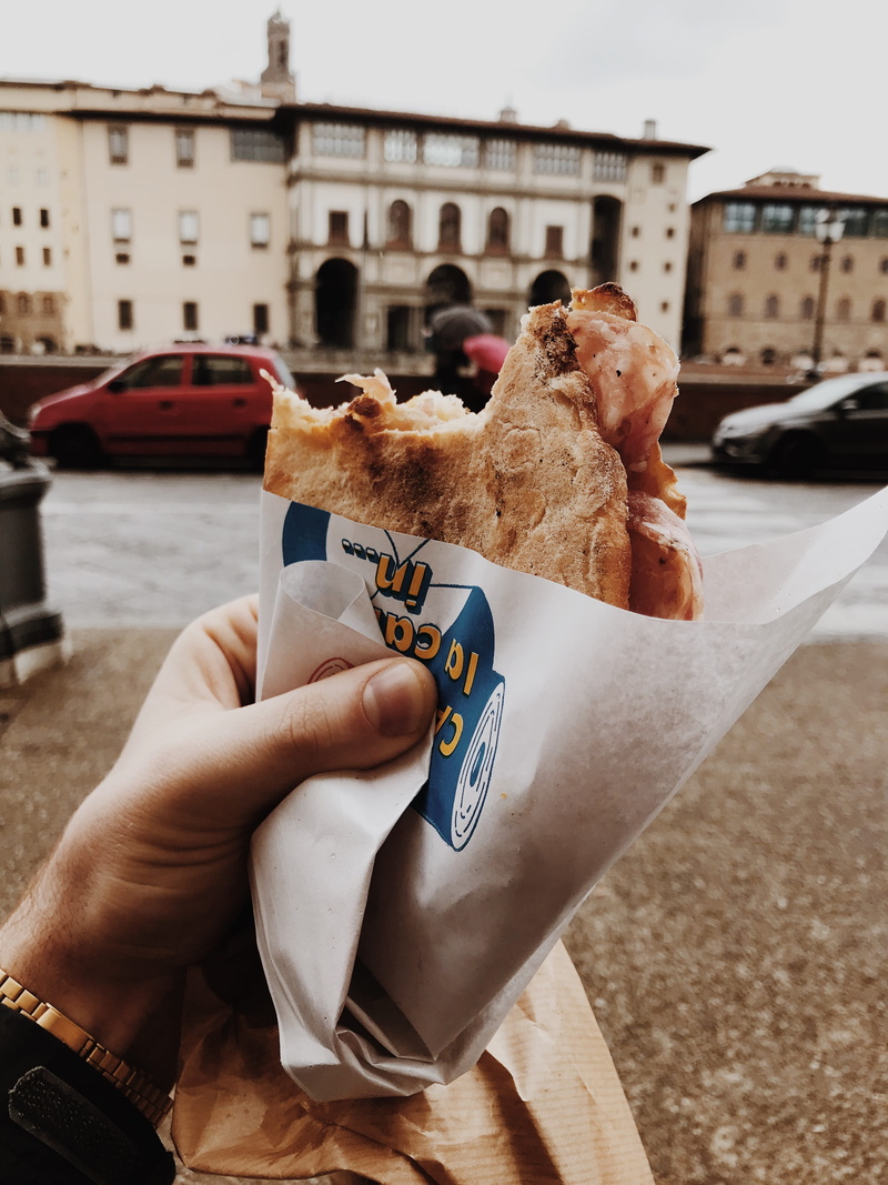 city, hand, street food, one person, travel, architecture, wrapped, food and drink, holding, close-up, focus on foreground, human hand, unrecognizable person