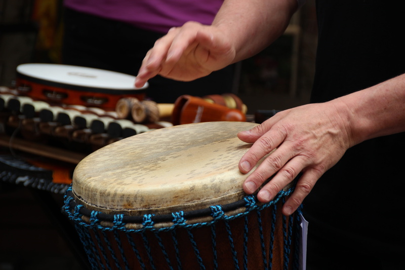 focus on foreground, human hand, midsection, artist, Rhythm, person, one person, holding, Music, playing, street music, human body part, Djembe, drumstick