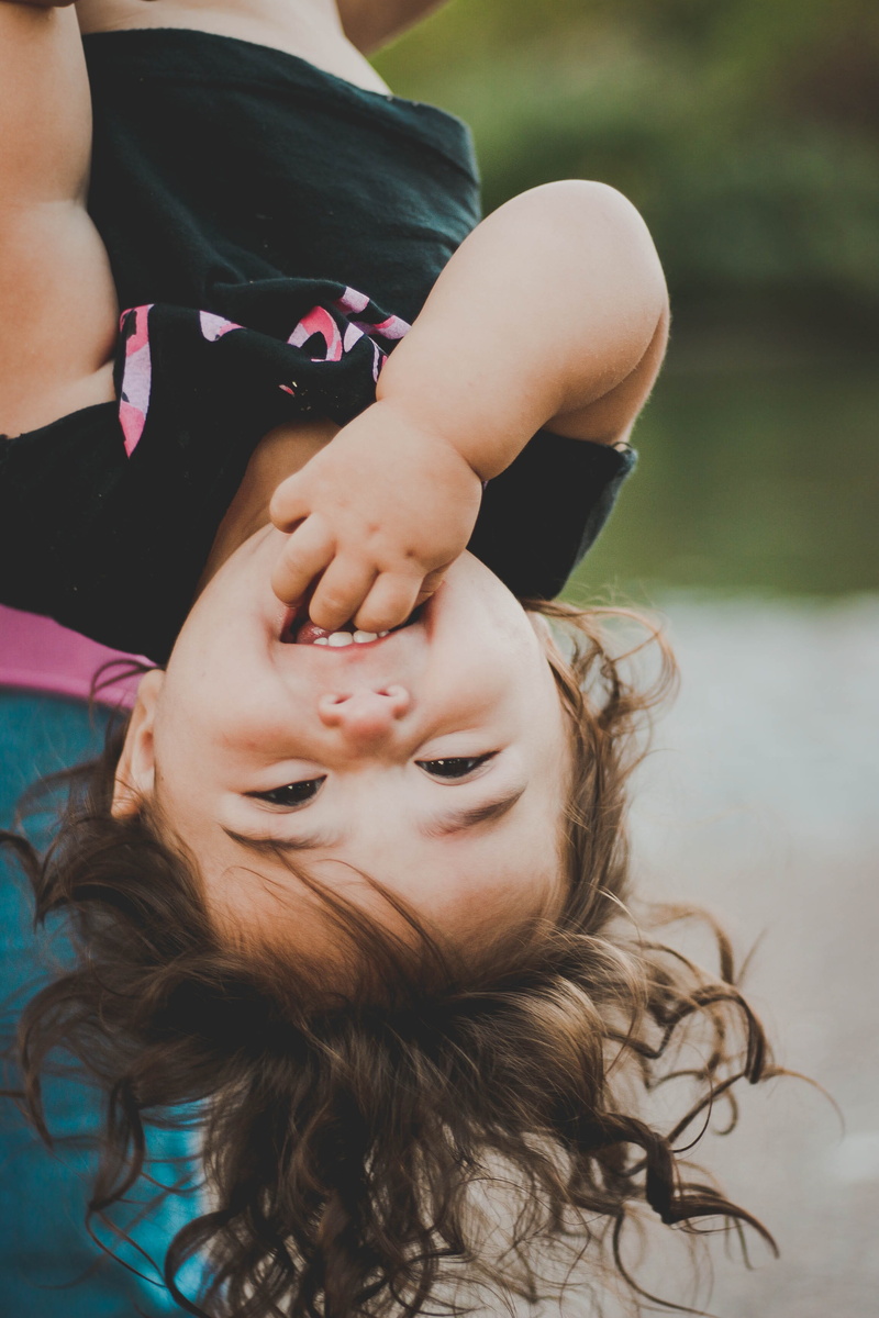 innocence, one person, women, happiness, females, female, fun, upside down, baby, child, childhood, shirt, hand, people, headshot, enjoy, black, casual clothing